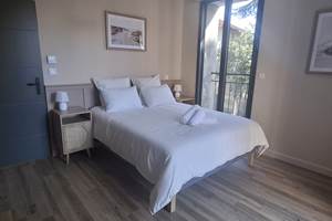 Suite parentale du gîte Le Pressoir à Montblanc, lit double et espace lumineux.