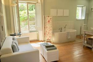 Salle de bain avec baignoire et coin salon aux chambres d'hôtes la Rougeanne près de Carcassonne