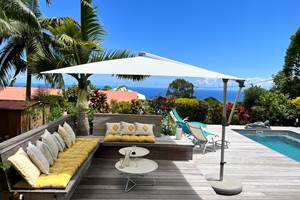 Espace repos sur piscine chauffée et jardin tropical avec vue mer