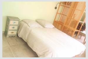Chambre au style naturel et épuré Lit double, mobilier en bois clair et ambiance douce : parfait pour un séjour reposant au cœur de La Flotte