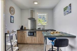 Espace cuisine et coin repas du Cocon d’Hell-Bourg, entièrement équipé et offrant une vue dégagée sur le Piton des Neiges, au cœur du cirque de Salazie.