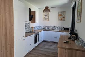 Cuisine entièrement équipée du gîte Le Pressoir à Montblanc, moderne et fonctionnelle.