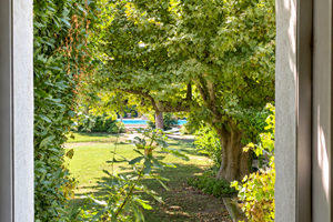 "Depuis la chambre, le regard s'ouvre sur le jardin arboré et la piscine du Mas"