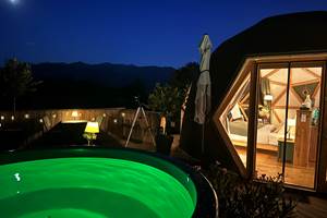 Profitez du bain nordique éclairé avec la vue sur les montagnes illuminées par la lune