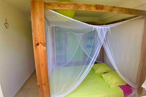 Chambre ventilée avec lit à baldaquin et moustiquaire