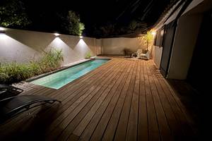 Ambiance magique autour de la piscine éclairée en soirée