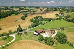 GITE LE GUITOU ET LE VILLAGE DE MONLEZUN AU LOIN LA PLAINE DE MARCIAC ET SON CLOCHER