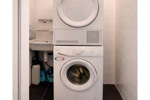 Espace buanderie équipé d’un lave-linge et d’un sèche-linge, pour un séjour confortable et sans contrainte.
