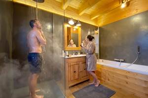 Grande salle de bain avec douche à l'italienne et baignoire balnéo