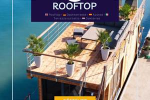 Grand rooftop avec salon extérieur et transats, offrant un espace de détente idéal avec vue dégagée sur l’eau et le paysage environnant.