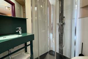 Salle de bain privative des chambres Twin 12 et 22 comprenant une belle douche, un lavabo, un sèche cheveux et toilettes