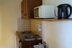 kitchenette équipée longs séjours avec ustensiles de cuisine, frigo, micro-ondes, cafetière.