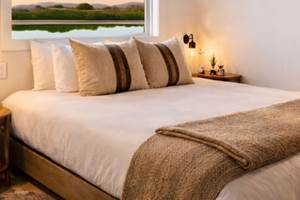 Chambre double du houseboat avec lit confortable, hébergement pour 4 personnes sur le canal du Rhône à Sète à Saint-Gilles.