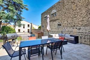 Terrasse privée du gîte Le Pressoir avec salon de jardin, table et barbecue