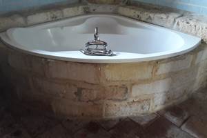 salle de bain avec baignoire d angle entouré de pierre de taille