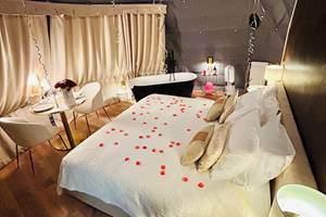 formule romantique avec ballons en coeur, pétales de roses, chocolats et champagne