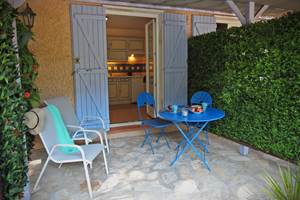 terrasse ombragée avec salon de jardin et fauteuils