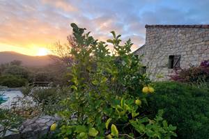 Maison d'hôtes traditionnelle en pierre de taille typique de la Corse du Sud au moment du crépuscule.