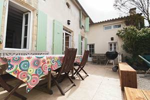 La Terrasse carrelée de la maison principale avec plusieurs tables