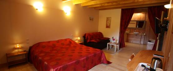 Vue d’ensemble de la chambre « Rubis » avec espace salon, TV, WIFI, Tisanerie