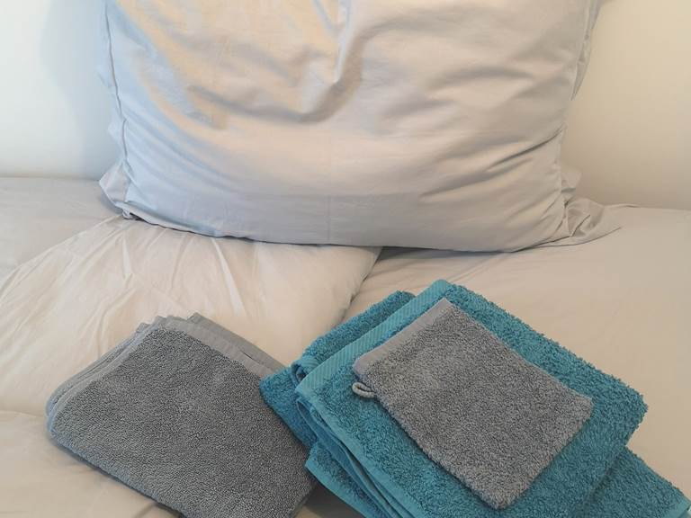 Linge de maison composé de draps de lit, housse de couette, taie d'oreillers, serviette de bain et tapis de douche.